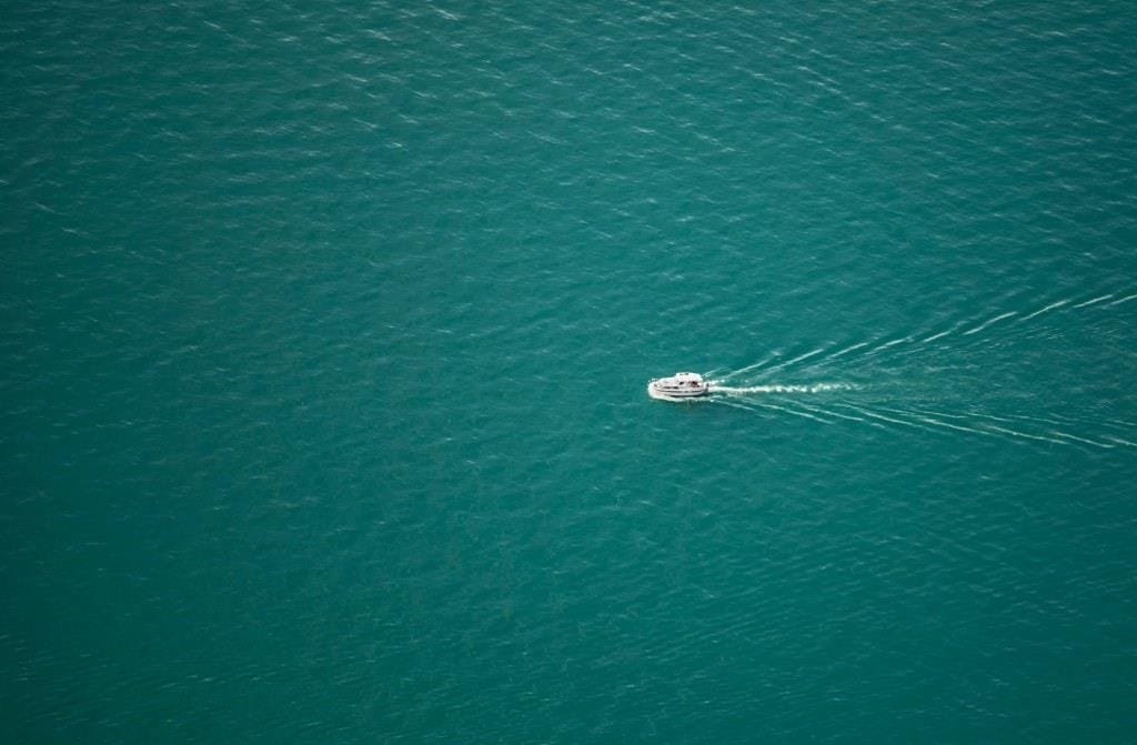 Imagen de un barco sobre fondo de mar, color TEAL, para el post de organizaciones Teal